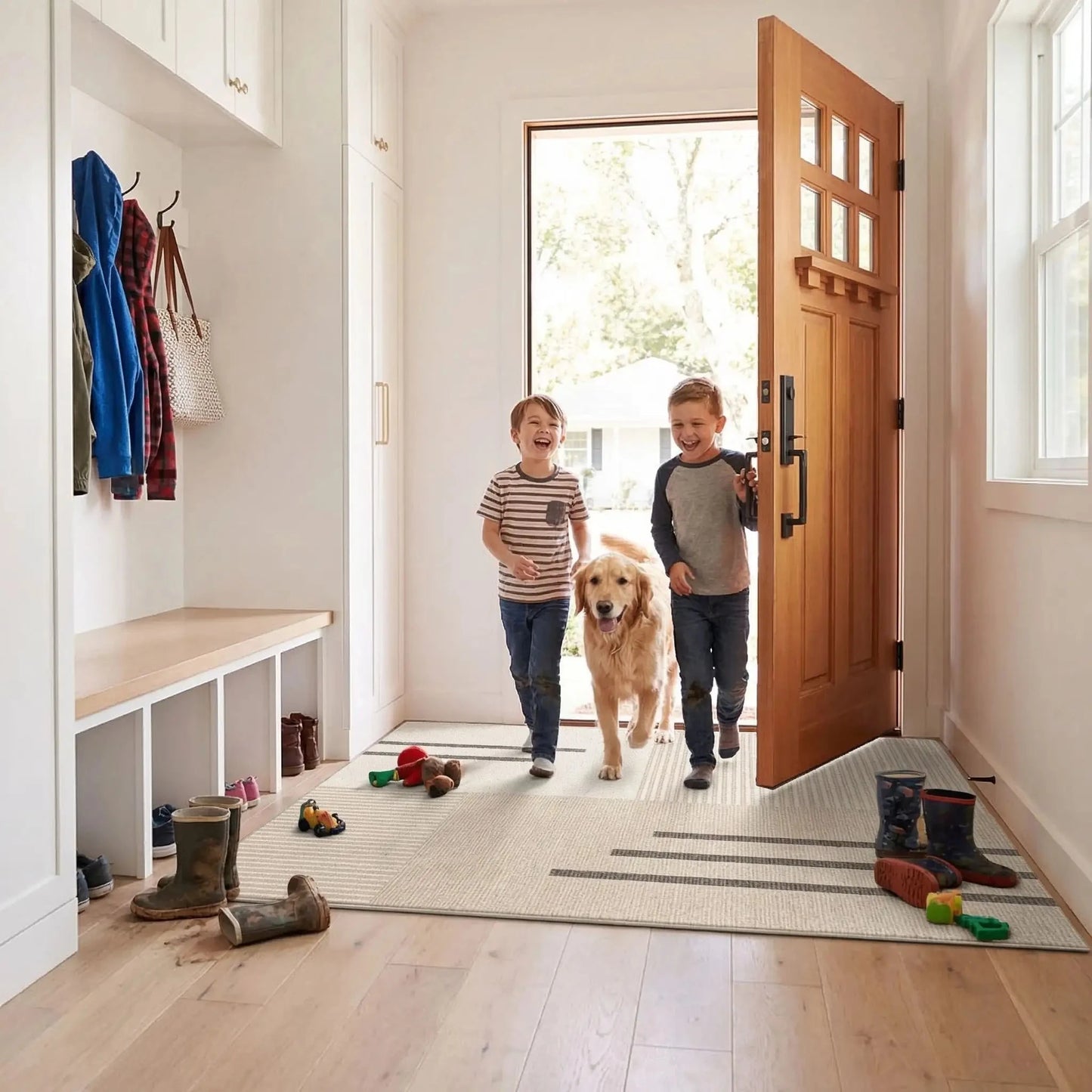 Grand tapis d’entrée antidérapant chic beige dans une entrée familiale avec enfants et chien.