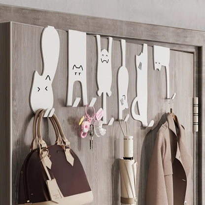 Crochets de porte sans perçage en forme de chats, utilisés pour accrocher sac, clés, manteau et parapluie dans une entrée organisée.