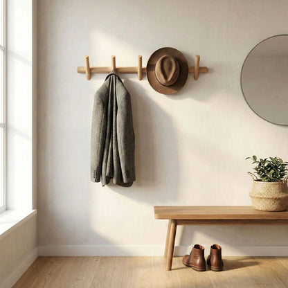 Vue d'ensemble d'une entrée zen avec un porte-manteau mural en bois, un miroir rond, une plante verte et un banc minimaliste.