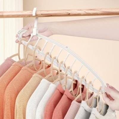 Démonstration de l'utilisation horizontale d'un cintre multi-niveaux blanc pour espacer les vêtements dans une penderie.