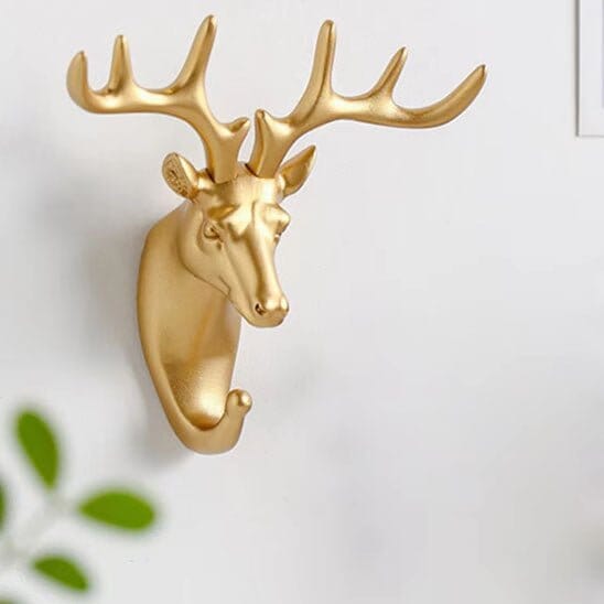 Crochet mural doré en forme de tête de biche, patère décorative et fonctionnelle pour une entrée chic.