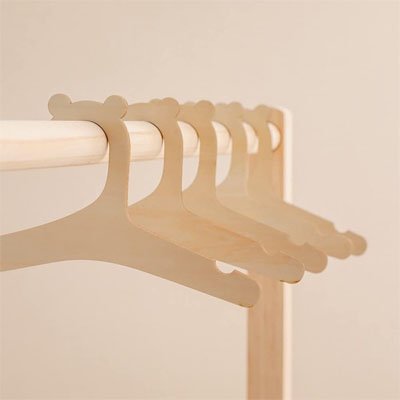Série de 5 cintres bébé en bois naturel suspendus, design épuré pour rangement de vêtements d'enfant.