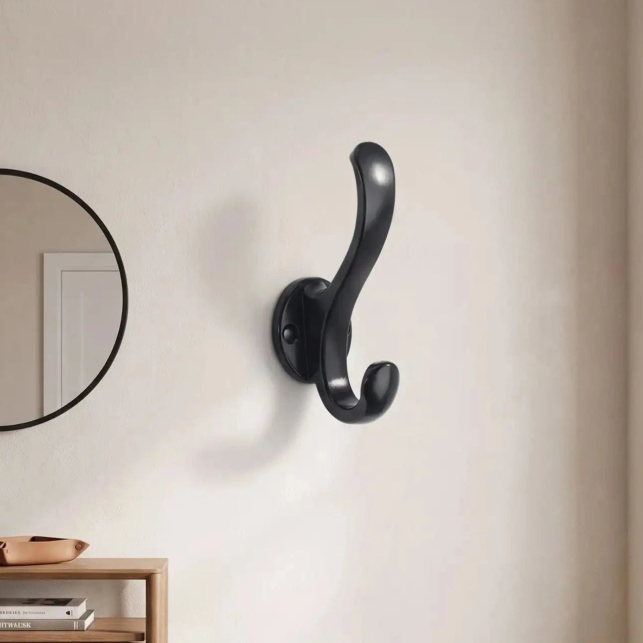 patère double crochet aluminium noir fixée au mur dans une entrée moderne