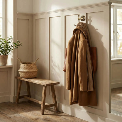 patere laiton antique dore sculpte avec manteau et sac dans un decor chaleureux