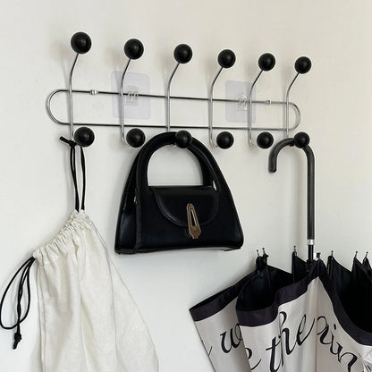 Patère porte-manteau murale design « Vintage Élégance » avec 6 crochets noirs, fixée sur un mur clair.