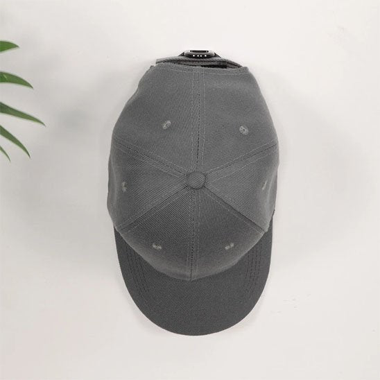 Support de rangement invisible OrganizPro pour casquette grise, effet flottant sur mur blanc pour une décoration murale épurée.