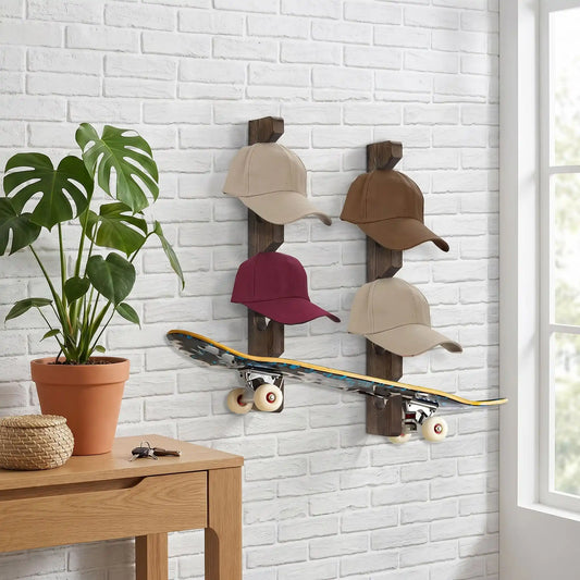 Deux range-casquettes muraux L'Exposeur en bois massif installés sur un mur de briques blanches à côté d'un skate-board et d'une plante en pot.