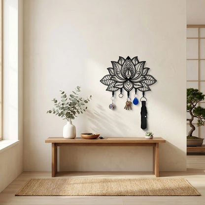 Porte-clé mural Lotus en métal noir avec 5 crochets installé sur un mur blanc au-dessus d'un meuble en bois.