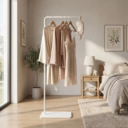 porte-manteau blanc sur pied minimaliste avec des vêtements beiges dans une chambre lumineuse au design scandinave
