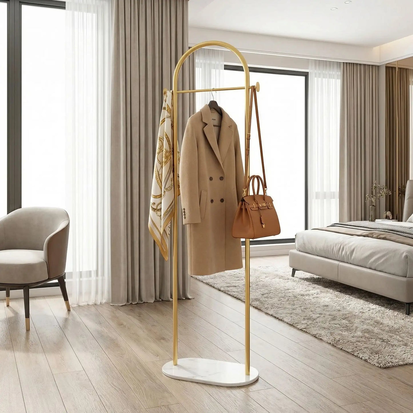 Porte-manteau design Soma en finition Or brossé, présenté dans une chambre luxueuse avec des vêtements élégants pour souligner la qualité haut de gamme.