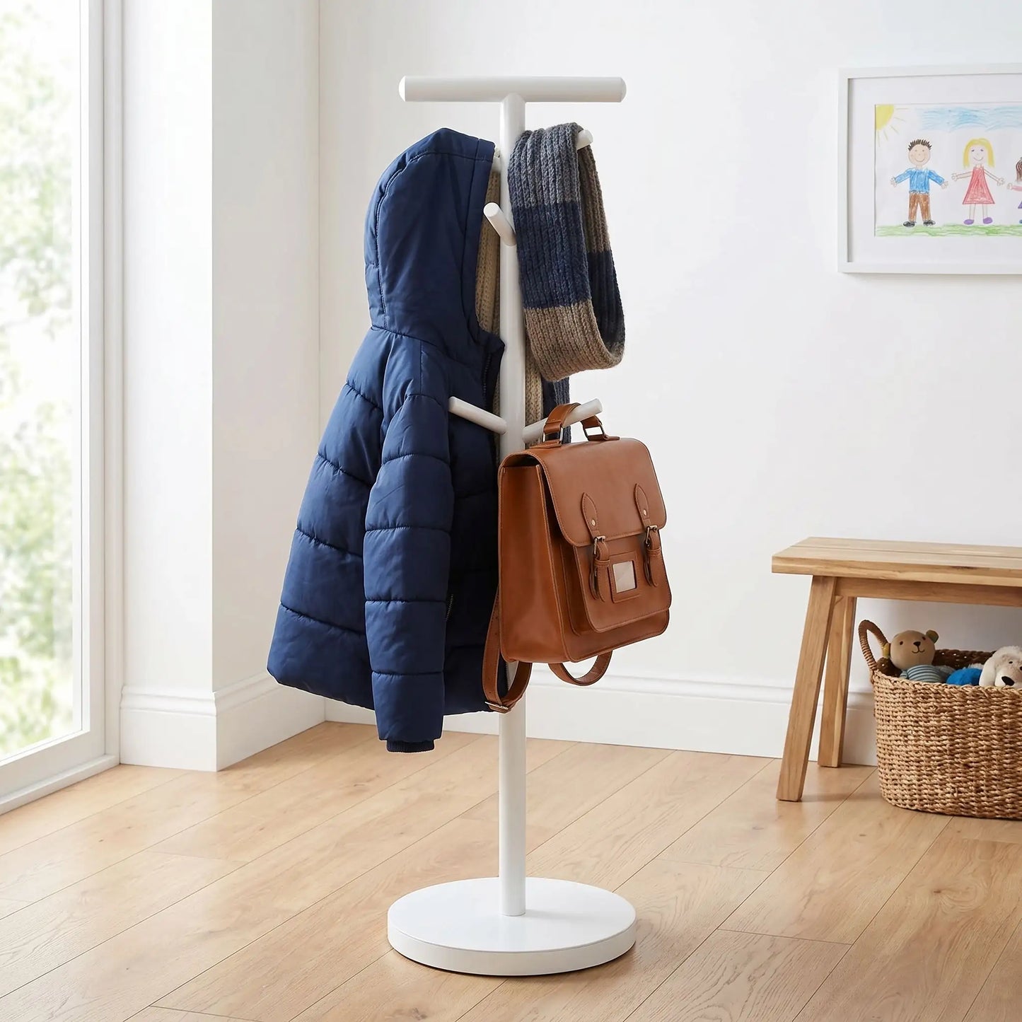 Porte-manteau enfant sur pied blanc en acier carbone chargé avec une veste et un cartable d'école pour illustrer la stabilité.