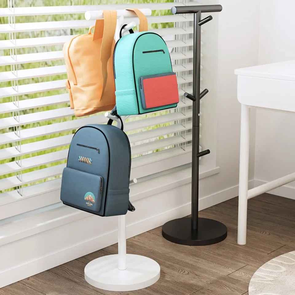 Porte-manteau enfant sur pied blanc et noir supportant plusieurs cartables et sacs d'école dans une chambre.