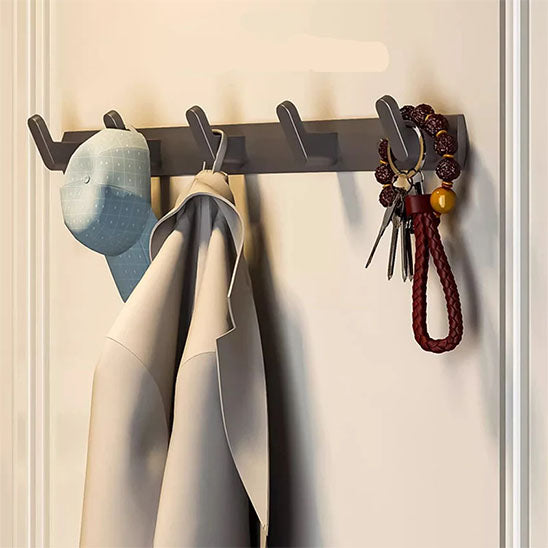 Porte-manteau mural Alumure en aluminium gris sidéral avec une veste, une casquette et des clés suspendues