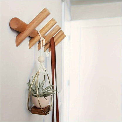 Détail d'un porte-manteau mural en bois avec une plante suspendue en macramé et un sac à main.Organique