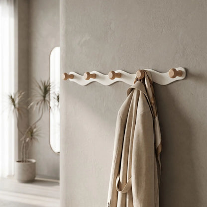 Porte-manteau mural design ondulé CréativeWaves™ blanc et bois naturel dans une entrée épurée.