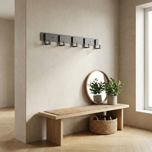 Porte-manteau mural gris mat au-dessus d'un banc dans une entrée au design épuré