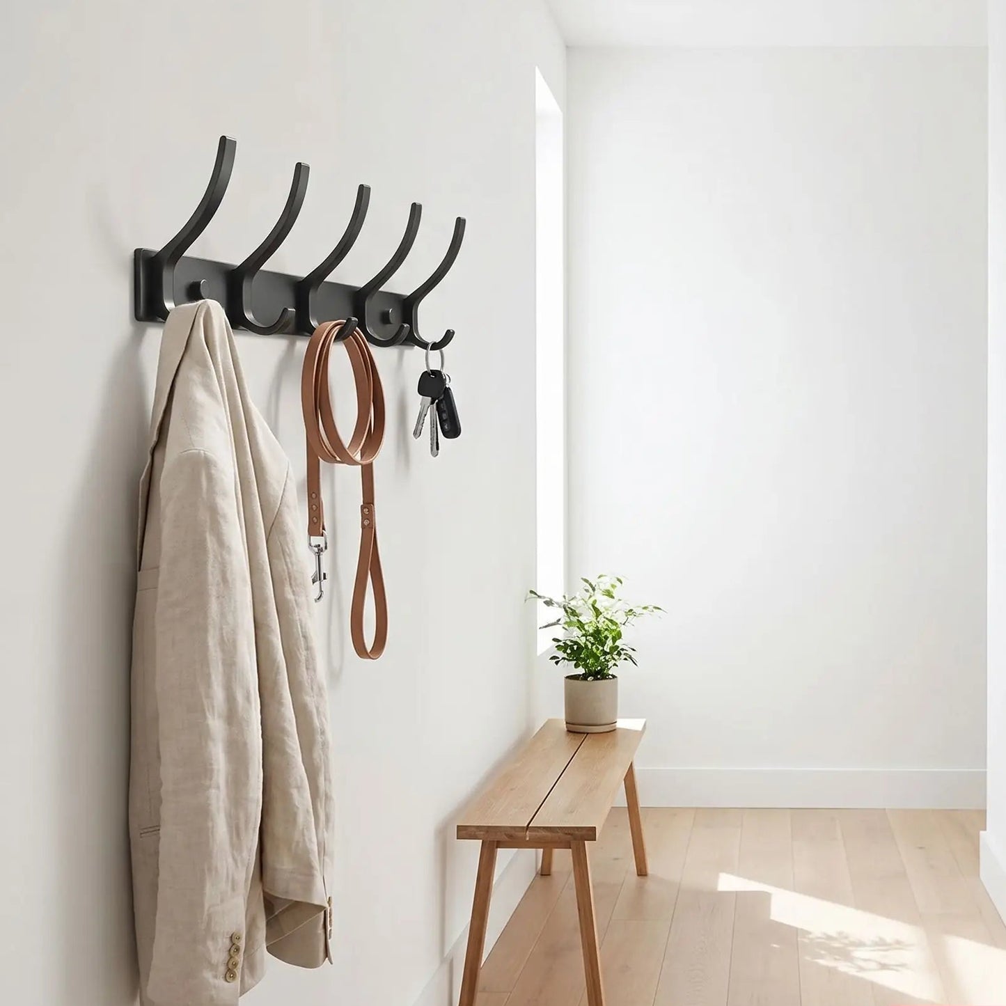 Porte-manteau mural Alumine noir mat installé dans un couloir étroit et lumineux, libérant l'espace au sol, style minimaliste.