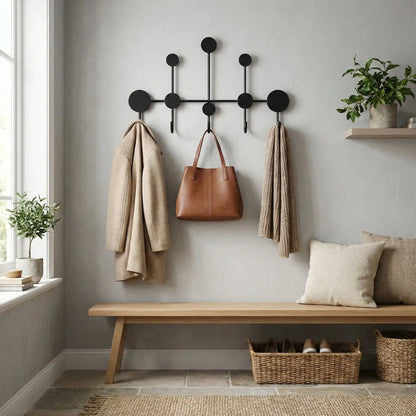 Porte-manteau mural design en fer forgé noir mat modèle Orno, avec 5 points d'accroche, supportant un sac à main en cuir et des vêtements.