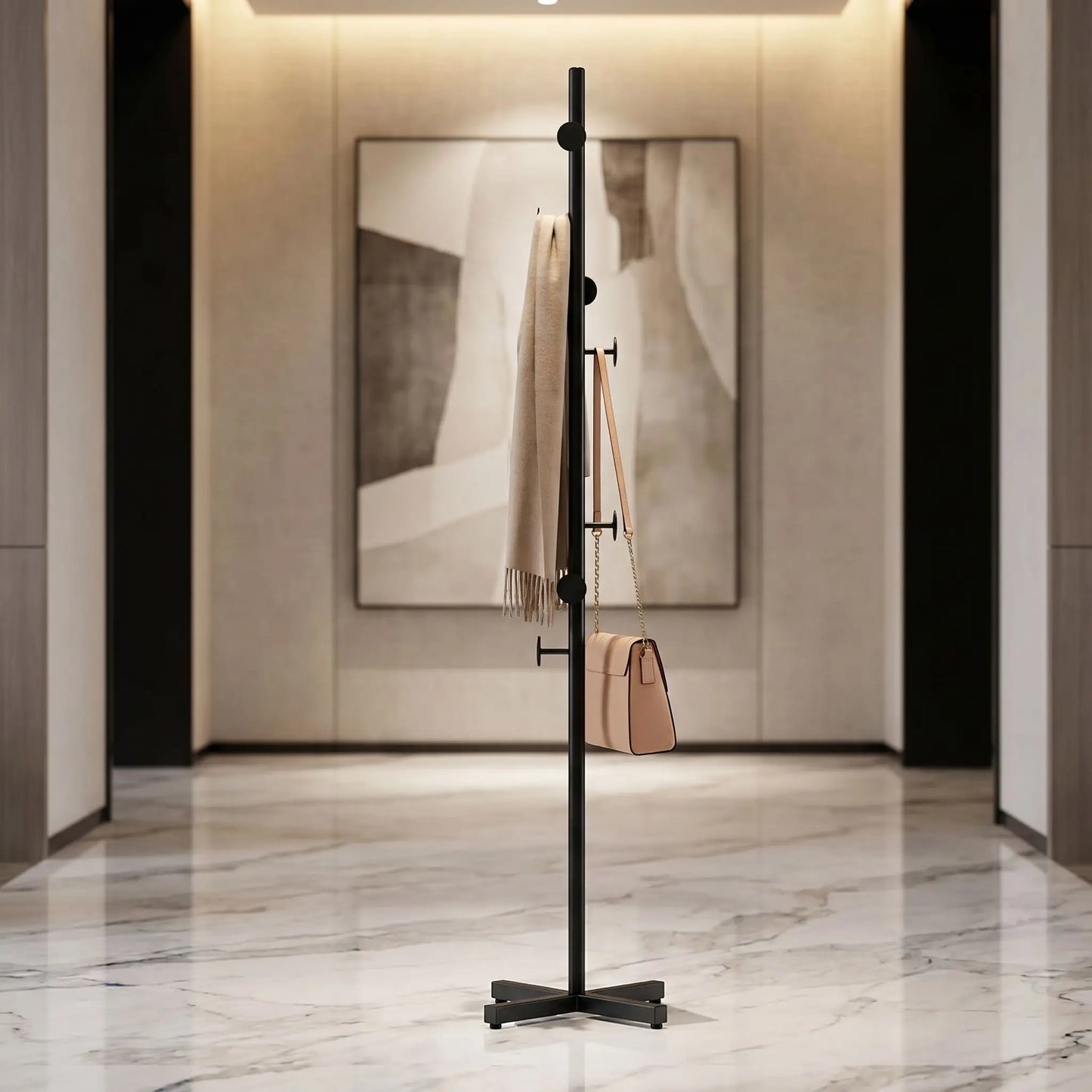 Porte-manteau design noir satiné Épure™ avec base en X stable, installé dans un hall d'entrée luxueux en marbre.