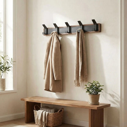 Porte-manteau patère mural en bois massif et métal noir installé dans une entrée moderne avec manteaux suspendus.