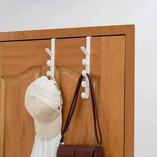 Deux porte-manteaux de porte Modèle Futé installés sur une porte en bois, supportant une casquette et un sac à main pour un gain de place immédiat.