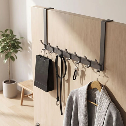 Porte-manteau de porte UrbanRack noir mat en aluminium spatial suspendu à une porte en bois blanche avec des vêtements