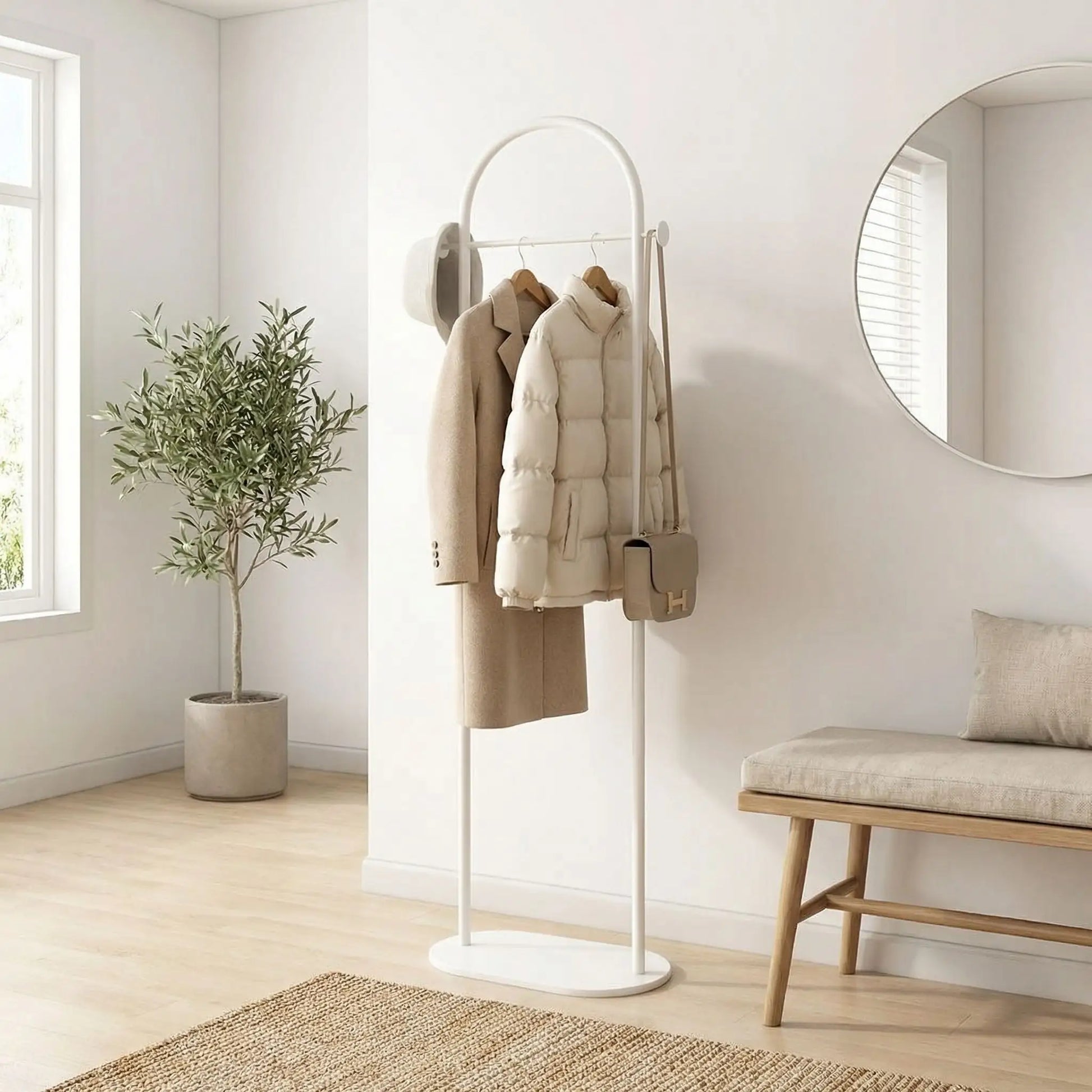 Porte-manteau sur pied blanc Soma au design scandinave, avec manteaux et sacs dans une entrée lumineuse et épurée.