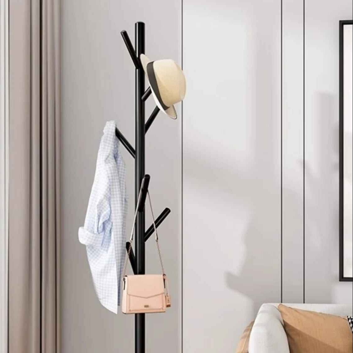 Porte-manteau sur pied noir en métal avec chapeau et veste, design minimaliste moderne pour entrée