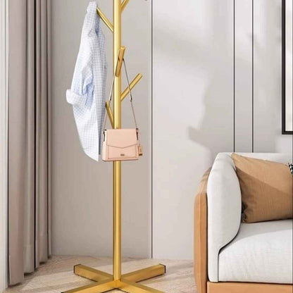 Porte-manteau sur pied doré en métal avec veste et sac, design chic pour chambre ou intérieur moderne
