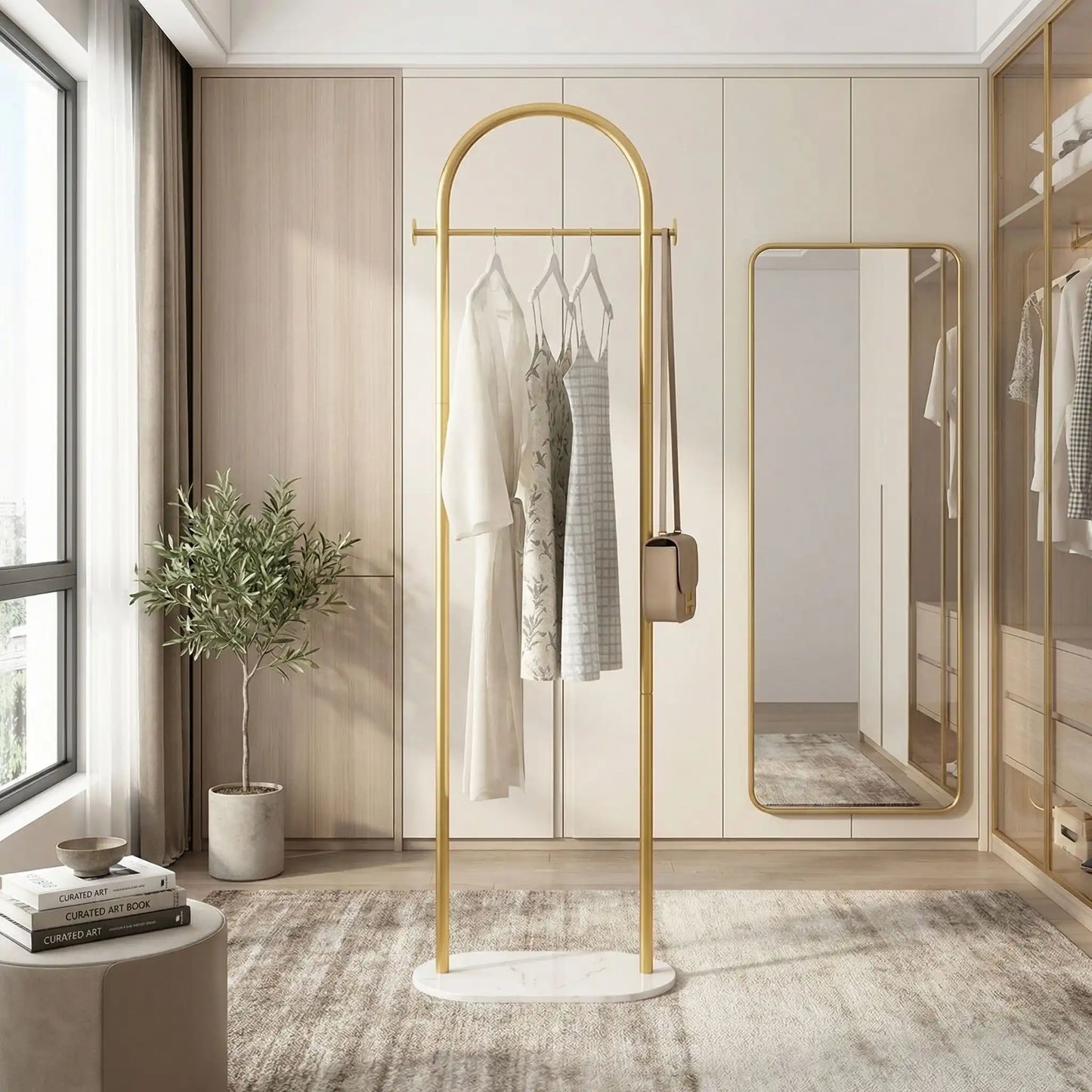 Porte-manteau sur pied Soma couleur Or (Gold) au design luxueux, avec cintres et vêtements dans un dressing moderne et lumineux.