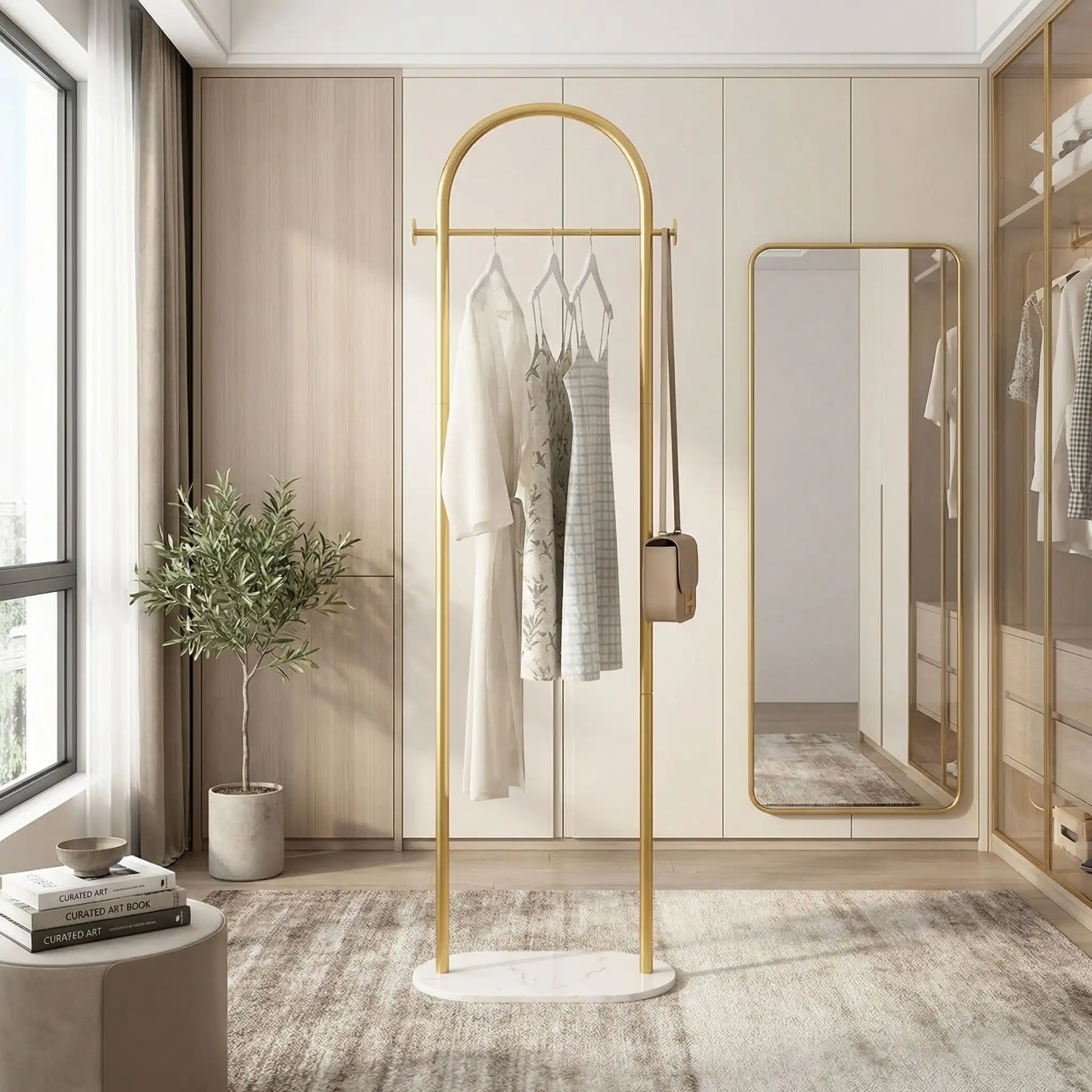 Porte-manteau sur pied Soma couleur Or (Gold) au design luxueux, avec cintres et vêtements dans un dressing moderne et lumineux.