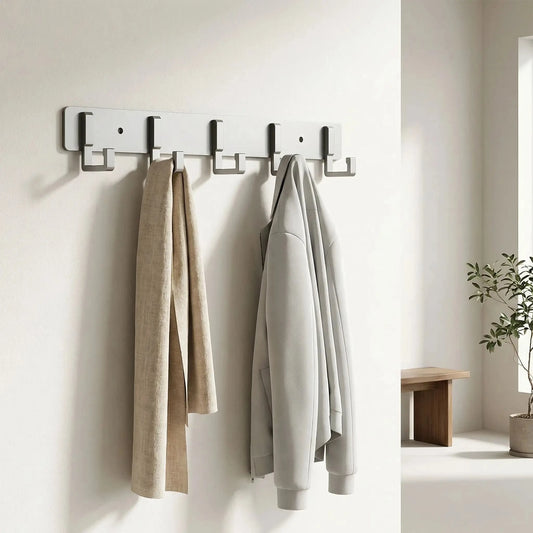 Porte-manteau mural design en aluminium gris avec plusieurs crochets et vestes suspendues dans une entrée lumineuse