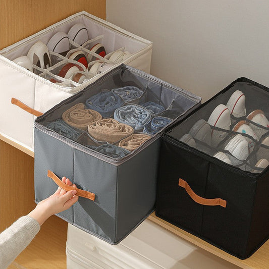 Main utilisant un module de rangement ShoeBox gris à côté d'un modèle noir et beige dans un dressing organisé.