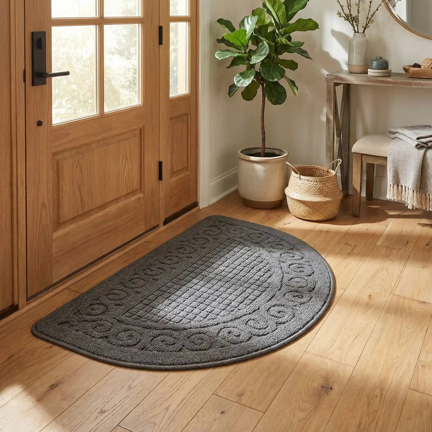 Entrée organisée avec tapis d’entrée intérieur demi‑lune antidérapant gris devant la porte. 