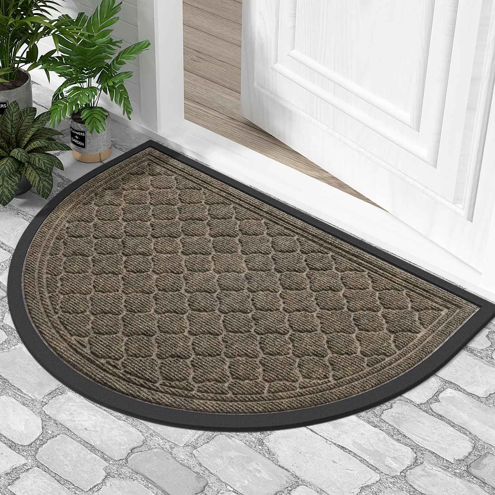 Tapis d'entrée demi-lune couleur Terre d'Ombre (marron) avec texture absorbante et bordure noire devant une porte d'entrée.