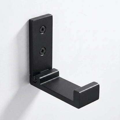 Gros plan sur le mécanisme d'une patère murale pliable noire Rangement Signature en alliage d'aluminium de qualité aéronautique.